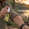 Person applying BugMace mosquito repellent outdoors before evening activities
