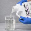 Alligare 5.4 Aquatic Herbicide 2 and a Half Gallon being poured into a graduated beaker for precise measurement before application.
