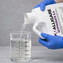 Alligare 5.4 Aquatic Herbicide 2 and a Half Gallon being poured into a graduated beaker for precise measurement before application.