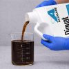 Alligare Diquat Gallon Herbicide being poured into a graduated beaker for precise measurement before application.