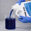 Cutrine Ultra being poured into a graduated beaker for precise measurement before application.
