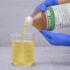 Cygnet Plus Spray Adjuvant being poured into a graduated beaker for precise measurement before application.