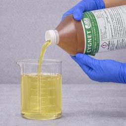 Cygnet Plus Spray Adjuvant being poured into a graduated beaker for precise measurement before application.