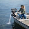 Female applicator applying white colored granules to lake water via boat mounted spreader.