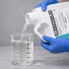 Hydrothol 191 being poured into a graduated beaker for precise measurement before application.