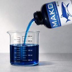 MAKO Concentrate Dye poured into a clear measuring cup beside the 32 oz bottle.
