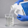 Sonar Genesis being poured into a graduated beaker for precise measurement before application.