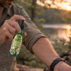 Person applying BugMace mosquito repellent outdoors before evening activities