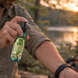 Person applying BugMace mosquito repellent outdoors before evening activities