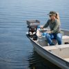Female applicator applying blue colored granules to lake via boat mounted spreader.