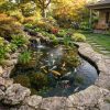 Clear backyard koi and garden pond with visible koi, waterfall, aquatic plants, and clean water supported by NT-MAX biological clarifier